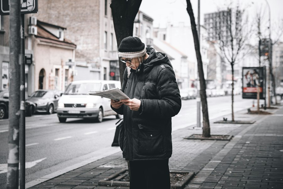 A man reading papers on a city street